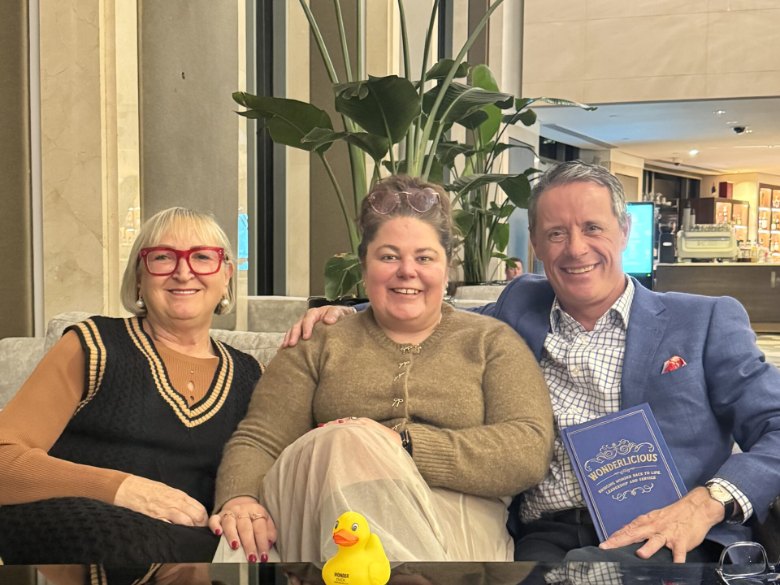 Crystal Adair-Benning with clients Peter Merrett and Avril Henry, Peter holding his published book Wonderlicious